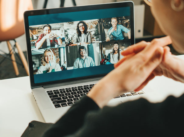 En person deltar i et videomøte på en bærbar datamaskin, med seks andre deltakere på skjermen. Bildet illustrerer digital kommunikasjon og fleksibiliteten ved kompetansanseavtale.